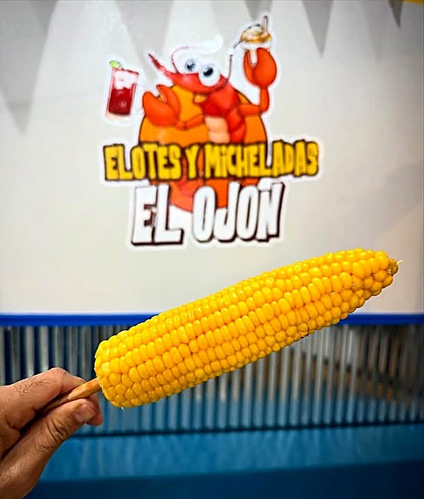 Elote frente al brand wall de El Ojón